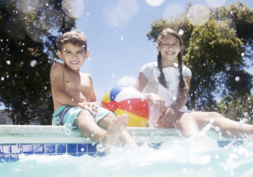 Kids sitting on edge of clean pool
